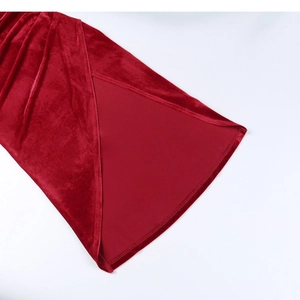 Detail shot of the high side slit and soft velvet fabric texture on a red dress