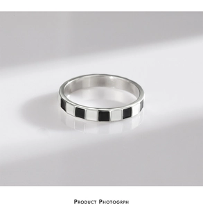 Macro shot of polished S925 silver ring with classic black and white checkered enamel