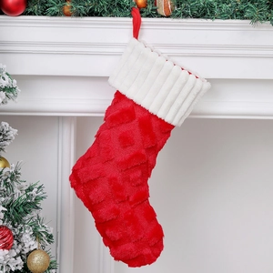 Close-up of red diamond pattern Christmas stocking hanging on a white fireplace mantle