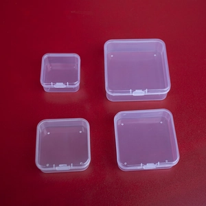Set of four transparent square PP plastic storage boxes with lids on red background
