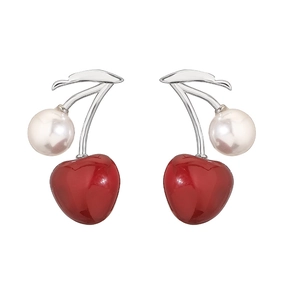 Close-up of elegant silver cherry earrings with a white pearl and a red glossy heart