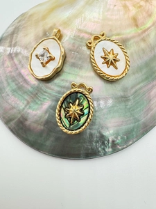 Detail of vintage 18K gold plated pendants with natural shell inlays and star patterns