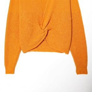Orange knit sweater featuring a stylish front twist knot detail and ribbed texture