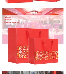 Detail of red festive paper gift bags with golden floral patterns and round rope handles
