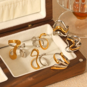 Detail view of two-tone gold and silver irregular geometric open ring in a wooden box