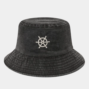 Close-up of white helm embroidery on washed grey cotton bucket hat with fine stitching