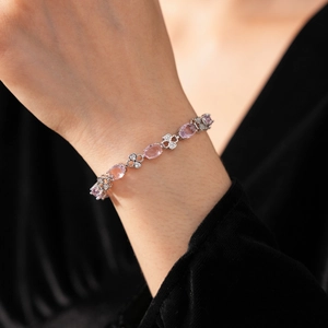 Detail of zircon geometric bracelet with pink stones and clover charms on wrist
