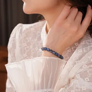 Elegant blue kyanite beaded bracelet on female wrist with white lace dress styling