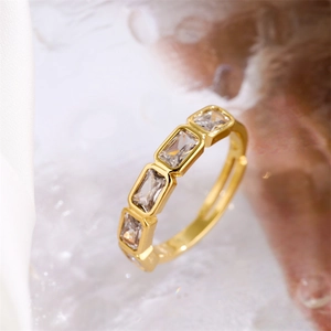 Gros plan sur une bague couronne dorée avec zircon cubique rectangulaire et anneau réglable