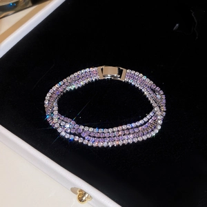 Makro-Detail von mehrlagigem Tennis-Armband mit lila und weißen Kristallen auf Samt
