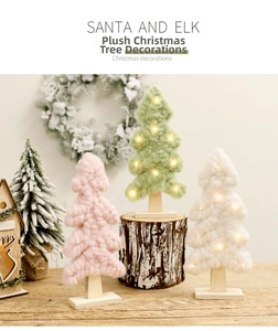 Detail of velvet Christmas trees with LED lights and wooden base on table