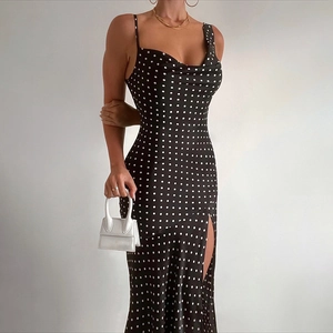 Detail shot of black polka dot slip dress featuring a cowl neck and side high slit design