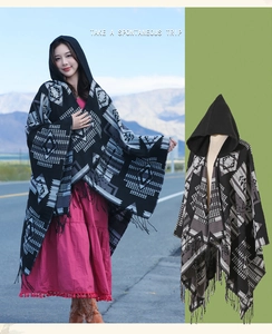 Close-up of bohemian hooded poncho with geometric patterns and tassel fringe detail