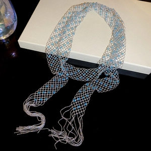 Detailed macro of silver hollow mesh necklace with light blue crystal beads and fringe