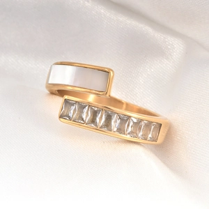 Detailed macro of golden 18k titanium ring with white shell inlay and baguette zircons
