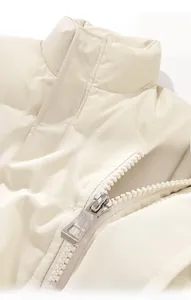 Detail showing standing collar and smooth metal zipper on quilted cream padded jacket