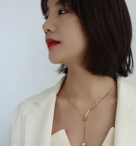 Detail of a 18k gold plated pin pendant necklace with fringe pearls on an Asian model