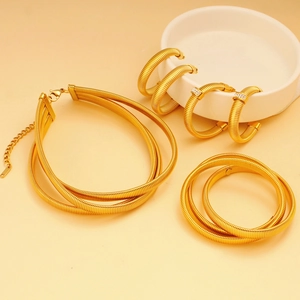 Detailed view of layered gold jewelry set with textured bracelets and circle earrings