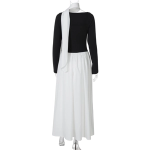 Back view of a long black and white contrast dress with neck tie on mannequin