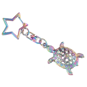 Rainbow metal sea turtle keychain with star clasp and hollow shell design on white background