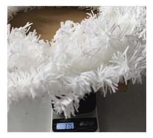 Detail view of the 375g white faux fur Christmas garland on a digital scale for weight check