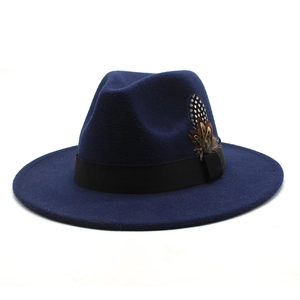 Close-up of navy blue wool fedora hat featuring black ribbon and decorative feathers