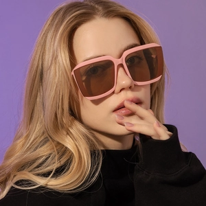 Fashionable pink square frame oversized sunglasses with brown lenses worn by female model
