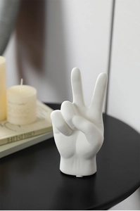 Macro detail of a white ceramic hand gesture sculpture in a minimalist Nordic decor setting