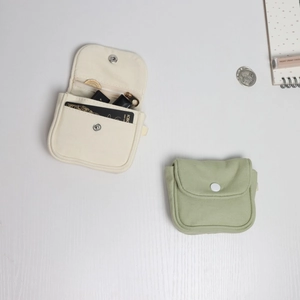 Detail of canvas coin purse with snap closure showing interior card slots and main compartment