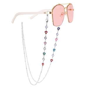 Detailed close-up of gold sunglasses with colorful heart pendants and crystal accents