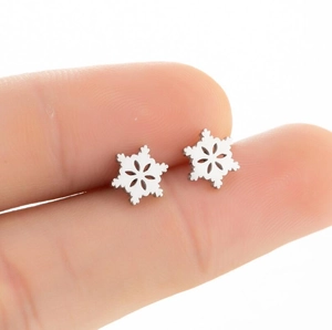 Macro shot of silver hollow snowflake stud earrings crafted from polished stainless steel