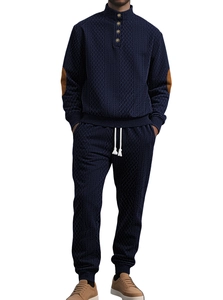 Detail of navy waffle knit tracksuit showing stand collar buttons and elbow patches