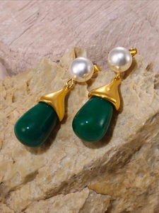 Detail of drop earrings with white pearls and dark green teardrop resin charms
