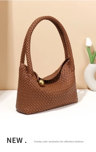 Close-up of caramel leather woven tote bag featuring a vintage gold metal ball clasp detail
