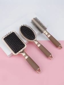 Close-up of a 3-piece hairbrush set with massage air cushions in elegant champagne gold