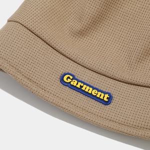Detailed view of khaki waffle knit texture and rubber Garment logo patch on bucket hat