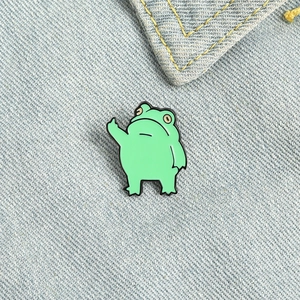 Simpatica Spilla in Smalto a Forma di Rana Verde Cartone Animato Creativa Gesto del Medio Spilla da Risvolto in Lega per Zaino