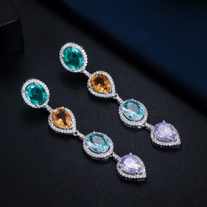 Macro view of crystal teardrop earrings with multi-colored gemstones and zircon stones
