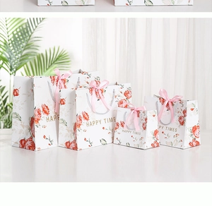 Detail of four marble pattern gift bags with red roses, pink ribbons and gold text
