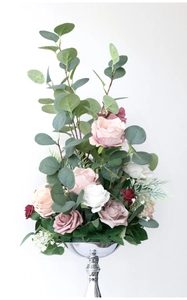Detailed arrangement of ivory and pink roses with greenery in a polished silver vase