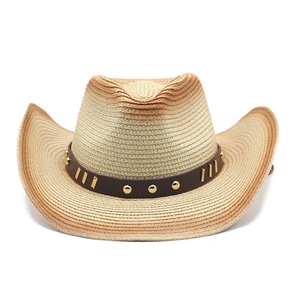 Dettaglio di un cappello da cowboy in paglia sfumata con borchie metalliche su fascia marrone