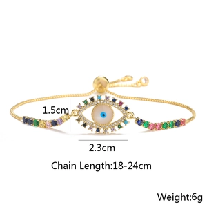 Close-up of golden evil eye bracelet with colorful zircons and adjustable slider chain