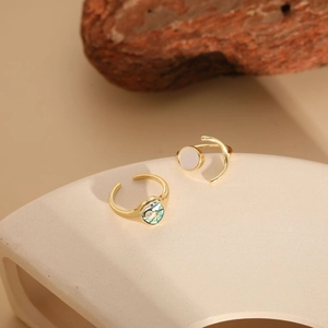 Detail of adjustable gold rings featuring white and abalone shell inlays in a set
