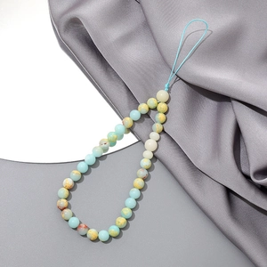 Close-up of light blue agate beaded phone strap on gray silk background fabric