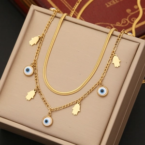 Gold layered stainless steel Hamsa hand and evil eye pendant necklace on display
