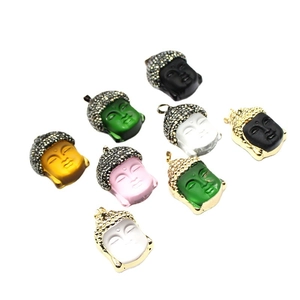 Colorful crystal Buddha head pendants with gold trim and rhinestones on white background