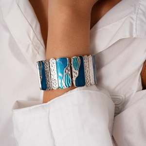 Detailed view of silver elastic bracelet featuring blue marbled enamel rectangular links