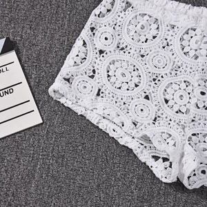 Dettaglio degli shorts in pizzo bianco all'uncinetto con delicati motivi floreali traforati