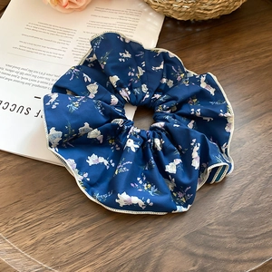 Detail of dark blue floral scrunchie with cute rabbit pattern and white wavy edges