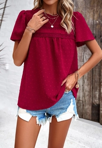 Detail of dark red short sleeve top with polka dot texture and delicate lace trim